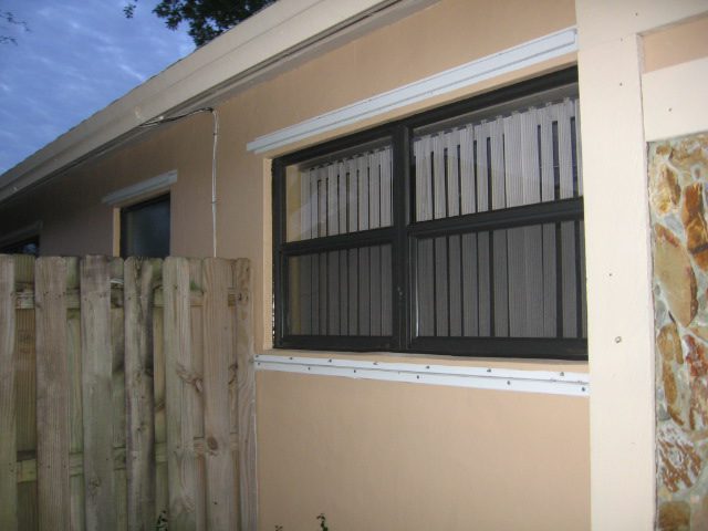 A window with bars on the outside of a house.