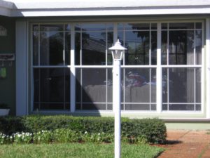 A white lamp post in front of a building.