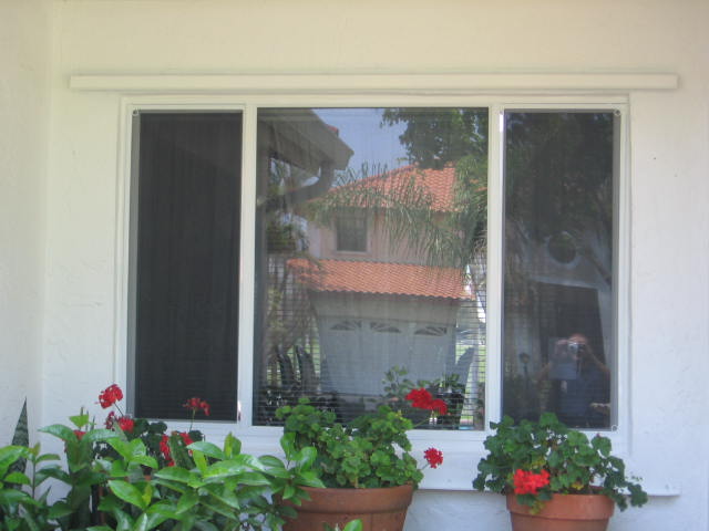 A window with three flower pots in front of it.